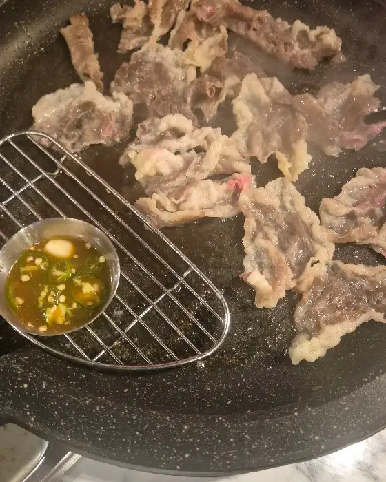 구워진 고기와 함께 놓인 하이볼 잔
