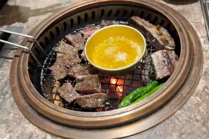 불판 위에서 익어가는 소갈비와 곁들임 채소