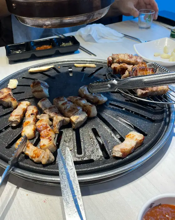 그릴 위에 맛있게 구워지고 있는 돼지고기 조각들