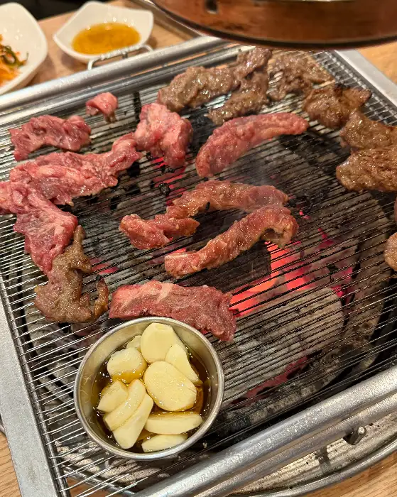 숯불 위에서 익어가는 소갈비살과 곁들임