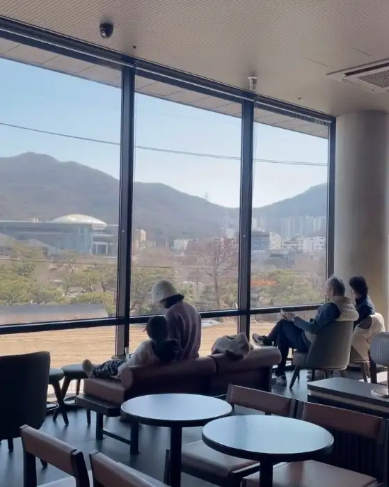 창가에 앉아 백운호수 풍경을 감상하는 사람들