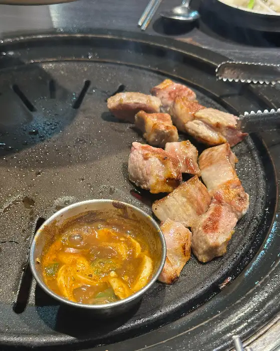 잘 구워진 삼겹살과 멜젓으로 보이는 소스