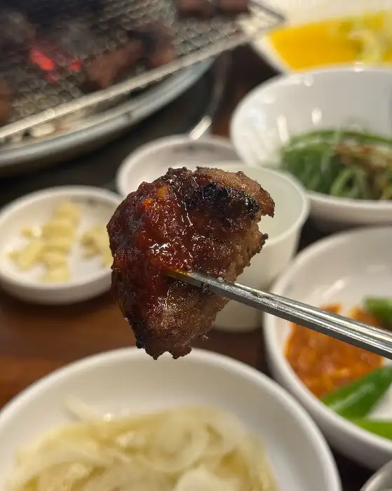 갈비를 집게로 집어 들어올린 모습