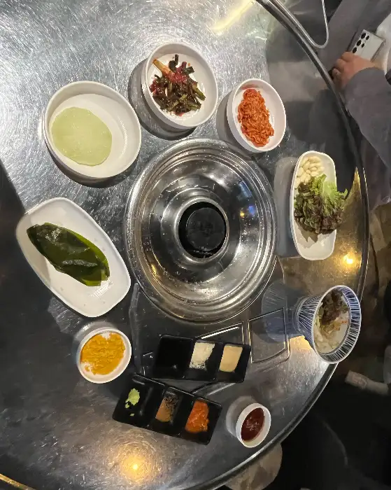 테이블 위에 세팅된 다양한 밑반찬과 소스들