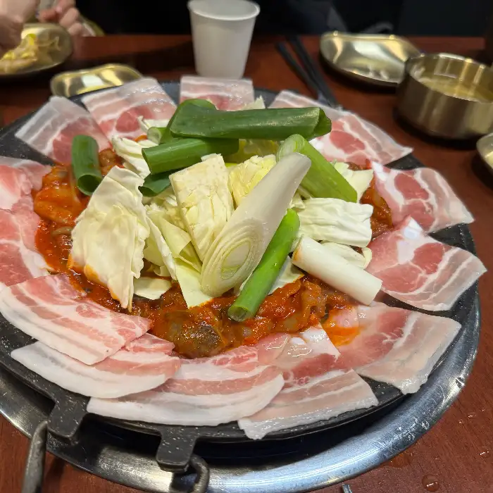 팬에 담겨 나온 쭈꾸미와 삼겹살, 채소의 모습 (다른 각도)