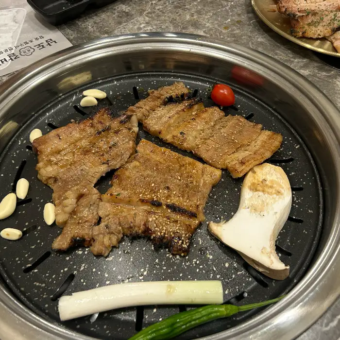그릴 위에서 익어가고 있는 갈비와 곁들임 재료들