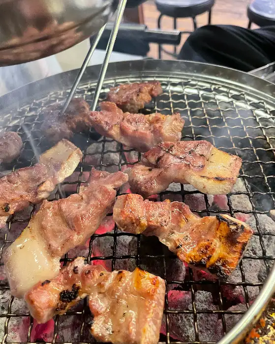 다양한 돼지고기 부위가 숯불 위에서 익어가는 모습