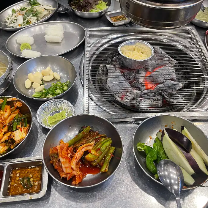 다양한 밑반찬과 숯불이 준비된 테이블 모습