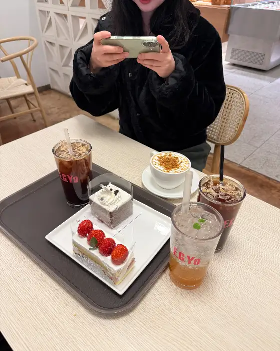 짙은 녹색 음료 위에 하얀색 크림이 소용돌이 모양으로 짜여져 있는 모습.