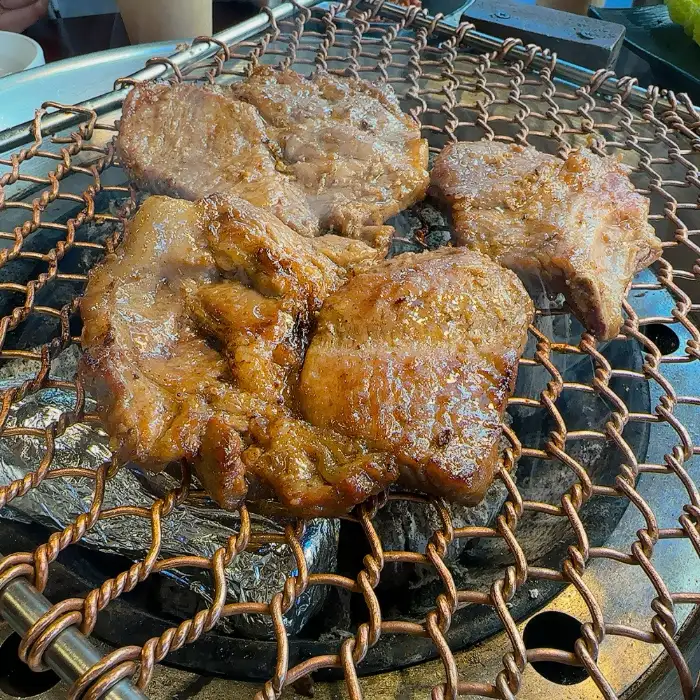 숯불 위에서 노릇하게 익어가는 돼지갈비