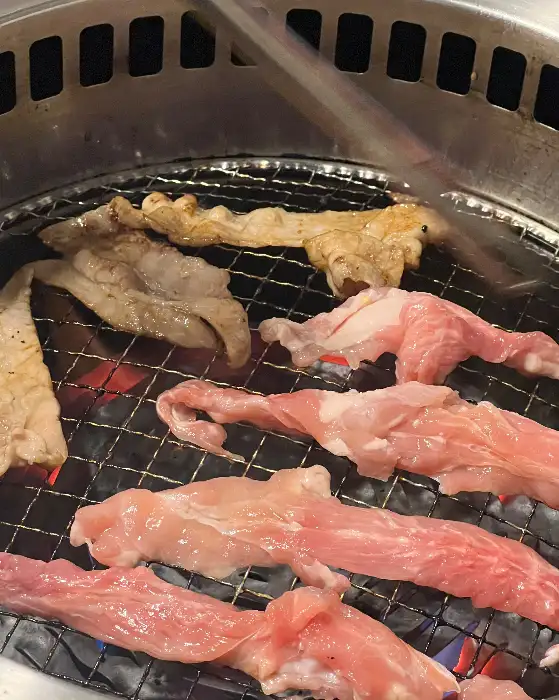 불판 위에서 구워지고 있는 여러 종류의 고기