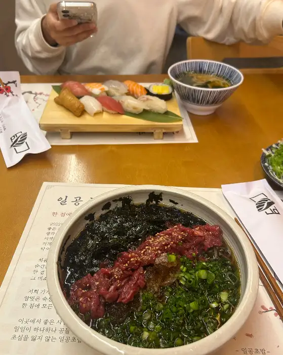 테이블 위에 놓인 초밥과 육회소바, 그리고 우동