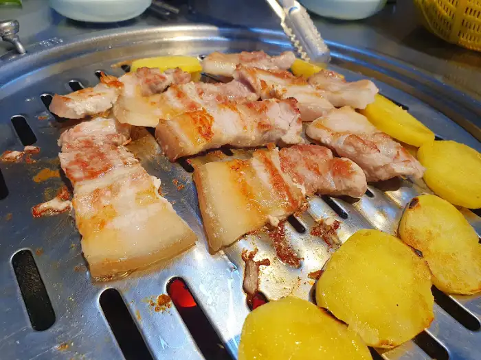 숯불 위에서 구워지는 생갈매기살과 감자