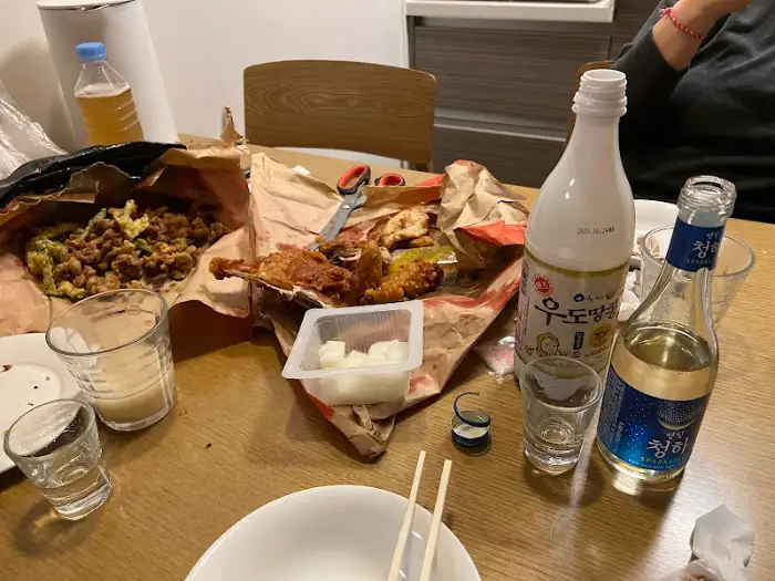 테이블 위에 놓인 다양한 치킨 메뉴와 술, 그리고 곁들임 찬