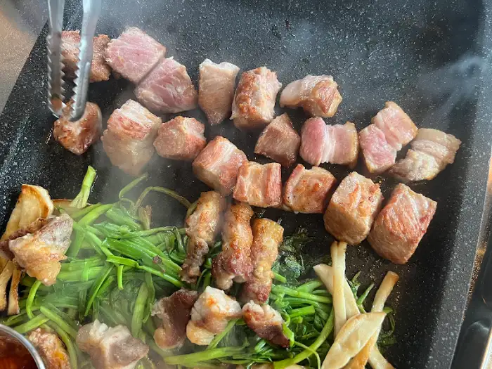 불판 위에서 맛있게 익어가는 고기와 채소들