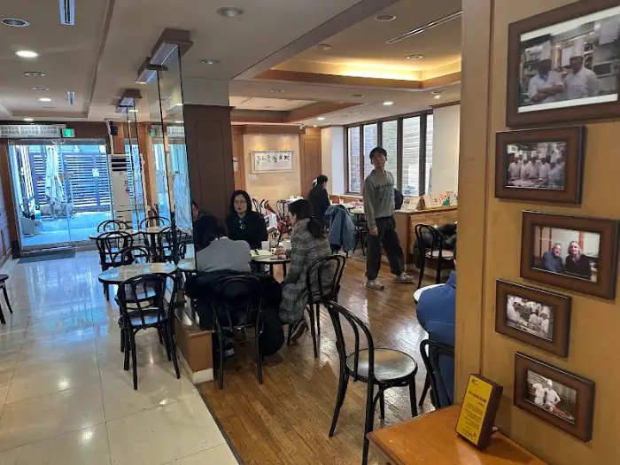 빵집 내부의 테이블과 의자, 사람들이 앉아있는 모습