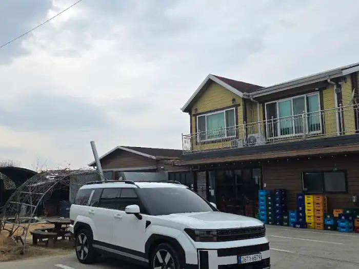 건물 외관과 그 앞에 주차된 하얀색 SUV