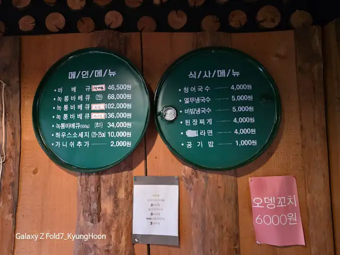 녹색 원형 간판에 적힌 다양한 고기 및 식사 메뉴