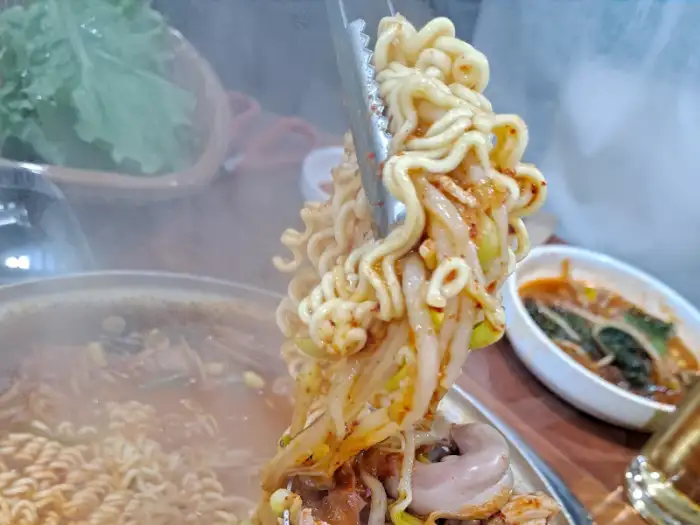 집게로 집은 곱창 조각 클로즈업