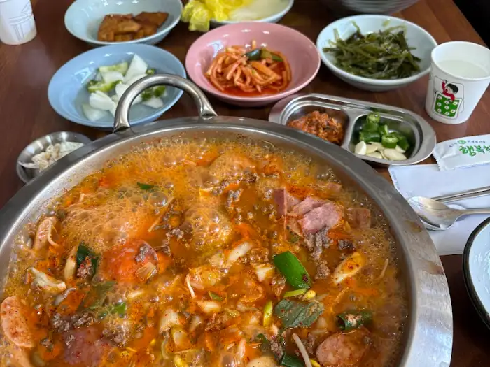 테이블 위 풍성한 반찬과 부대찌개