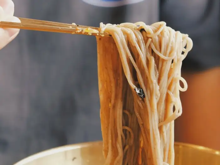 젓가락으로 집어 올린 막국수 면