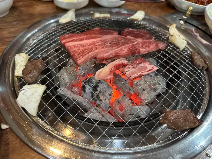 다양한 부위의 소고기가 숯불 위에서 익어가고 있는 모습