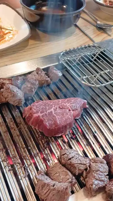 숯불 위에서 지글지글 익어가는 두툼한 한우 안심