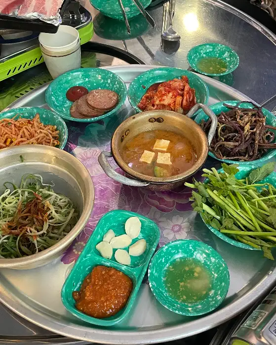 다양한 쌈 채소와 곁들임 재료가 담긴 그릇들