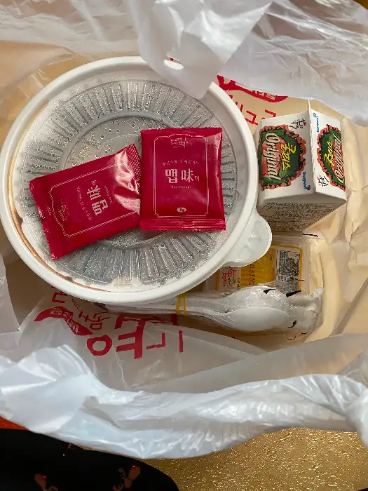 떡볶이 용기와 엽기 소스, 쿨피스, 젓가락이 담긴 봉투