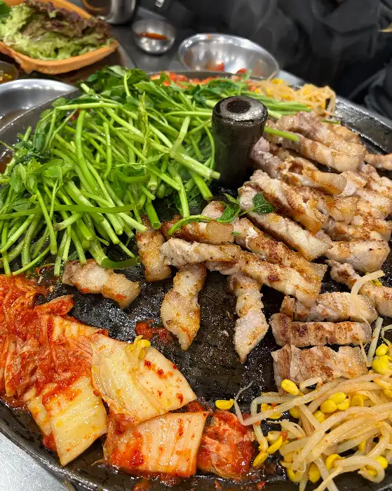 직원이 능숙하게 고기를 뒤집고 자르는 모습