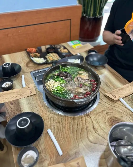 테이블 위에 푸짐하게 차려진 백숙과 밑반찬들