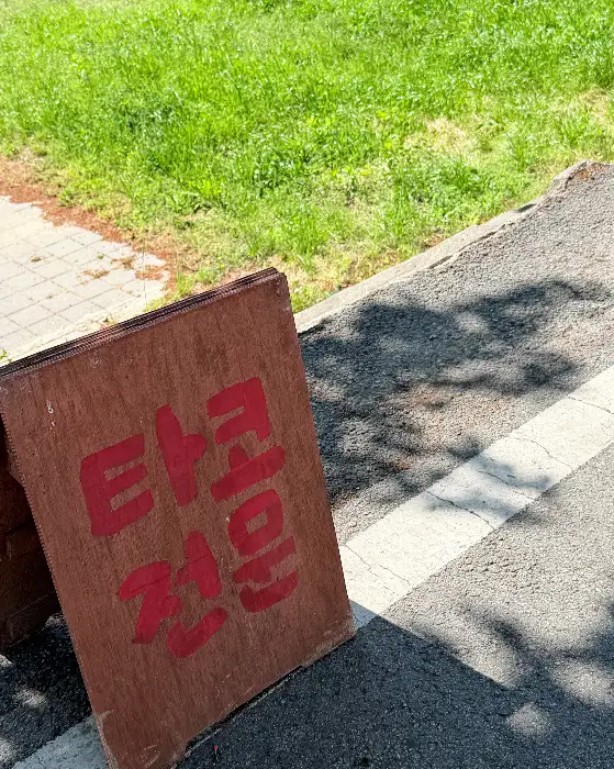 나무 간판에 '타코 전골'이라고 쓰여 있는 모습