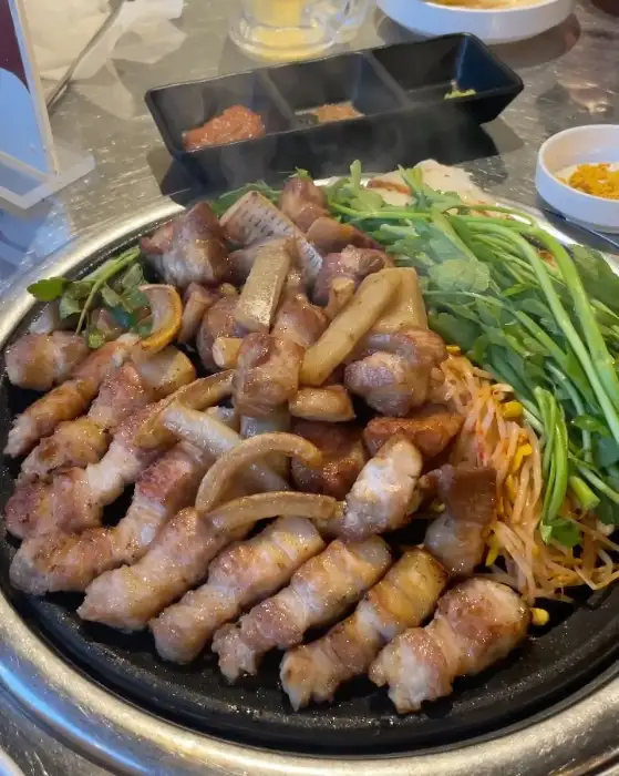 잘 구워진 삼겹살과 목살, 그리고 곁들임 채소들