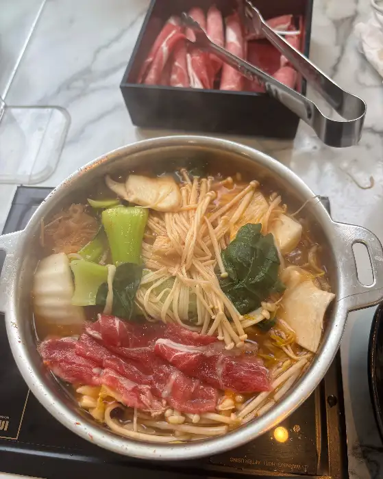 샤브샤브 냄비 가득 담긴 고기, 채소, 버섯