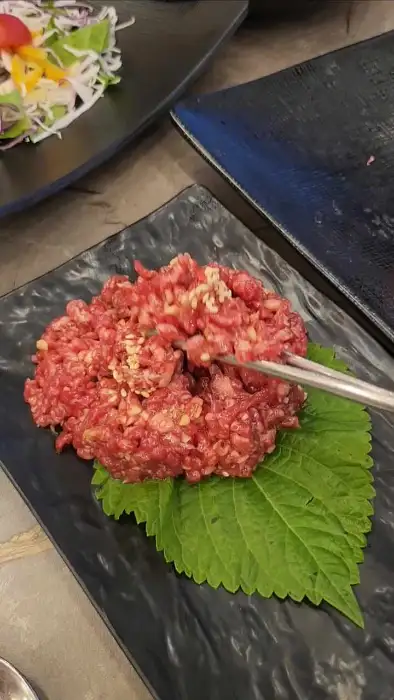 젓가락으로 집어 올리는 육회