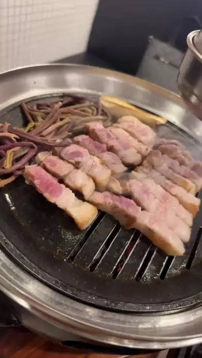 불판 위에서 익어가는 고기와 함께 곁들여진 고사리
