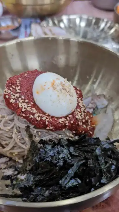 그릇에 담긴 비빔막국수와 반숙 계란