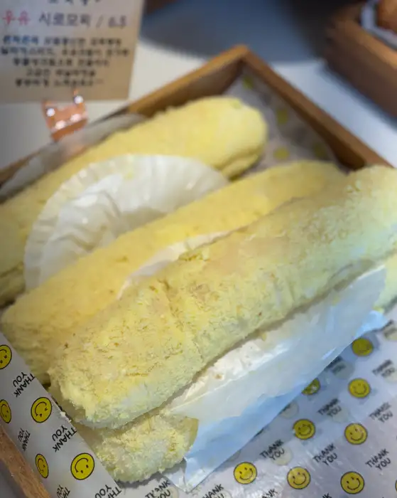 노란색 가루를 묻힌 롤케이크 여러 개