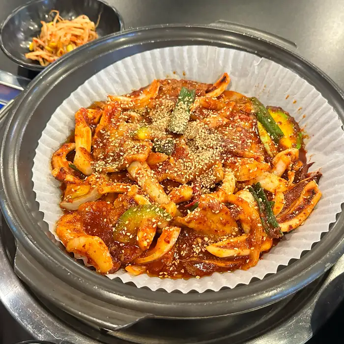 빨간 양념에 버무려진 오징어와 채소 요리