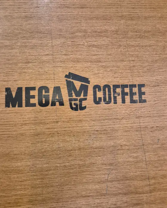 메가MGC커피 로고가 새겨진 나무 테이블