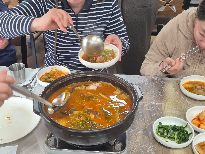 따뜻한 매운탕을 국자로 떠서 그릇에 담고 있는 모습