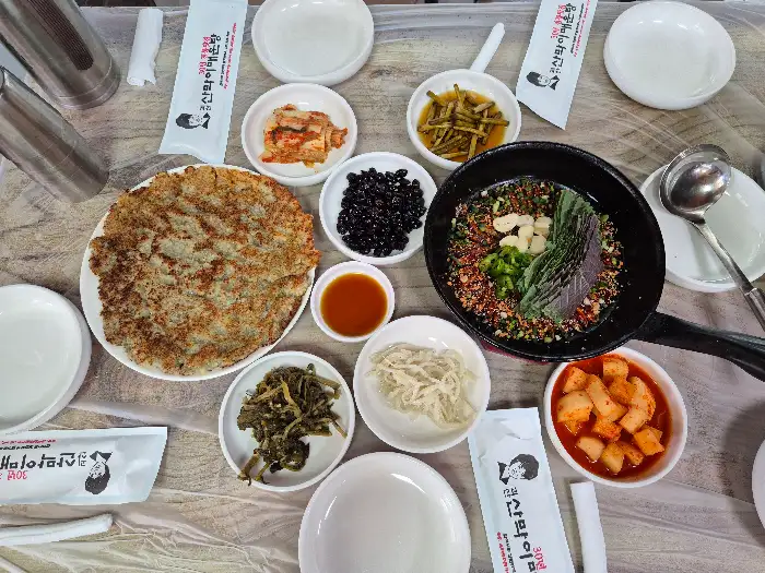 큰 감자전과 여러 가지 반찬, 도리뱅뱅이 놓인 테이블