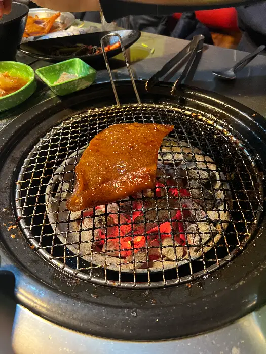 숯불 위에서 노릇하게 구워지고 있는 돼지껍데기
