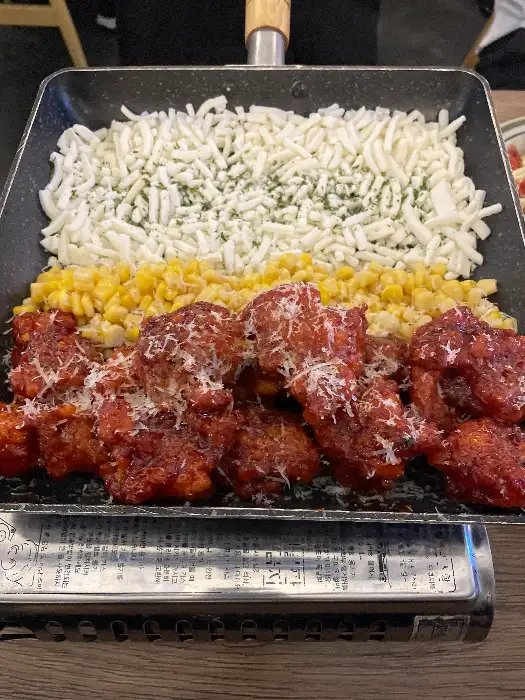 불판에 올라간 치킨과 옥수수, 치즈