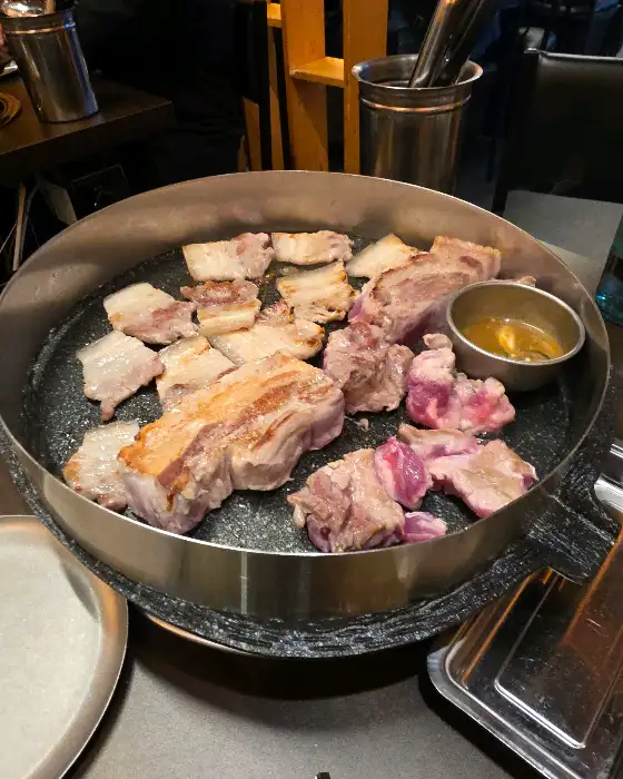 오겹살과 목살이 불판에서 노릇하게 구워지고 있는 모습