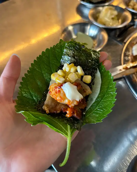 깻잎 위에 쭈꾸미, 옥수수콘, 마요네즈 등이 올려진 쌈