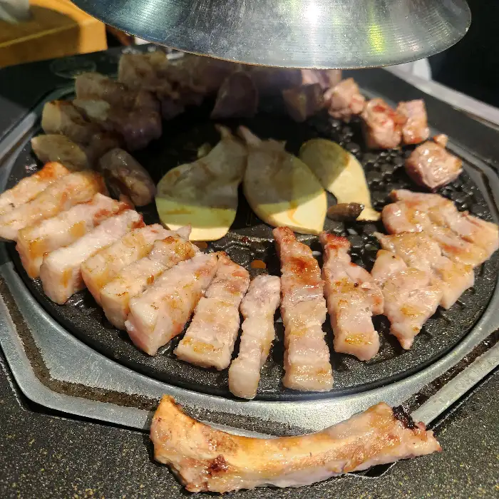 잘 구워진 고기 조각과 곁들임 반찬