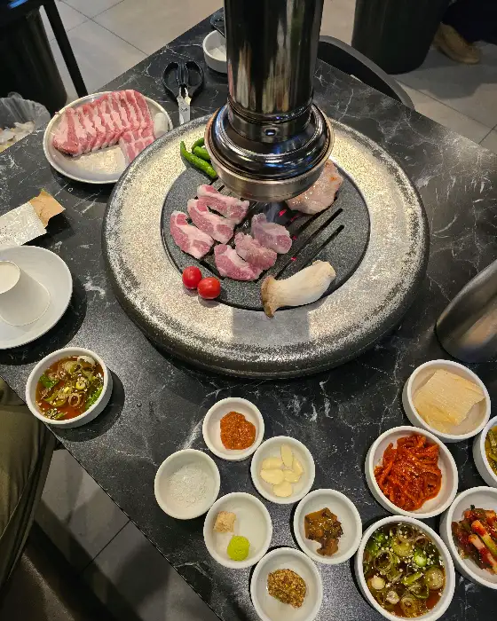 잘 익은 고기 조각들이 불판 위에서 먹음직스럽게 놓여 있음