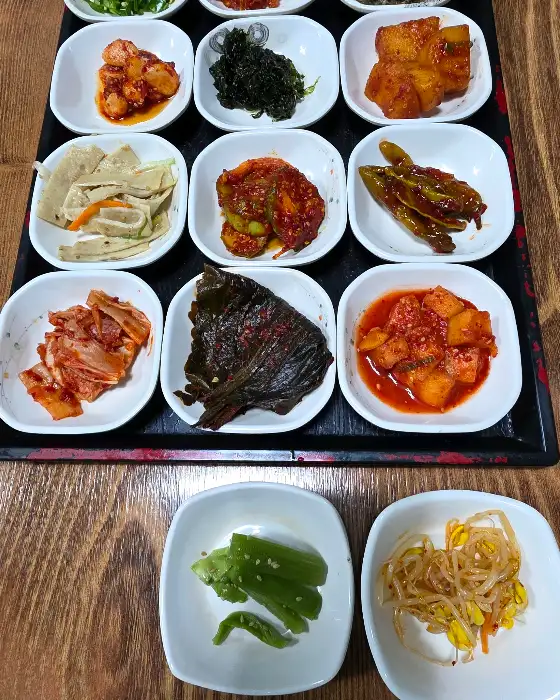 작은 접시에 담긴 다양한 종류의 나물과 김치, 멸치볶음 등 밑반찬들