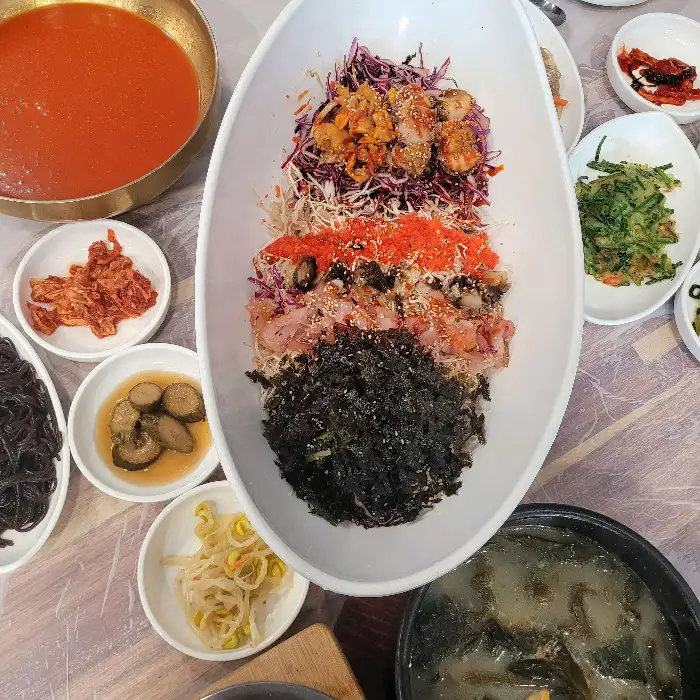먹음직스럽게 차려진 해산물 비빔밥과 곁들임 반찬
